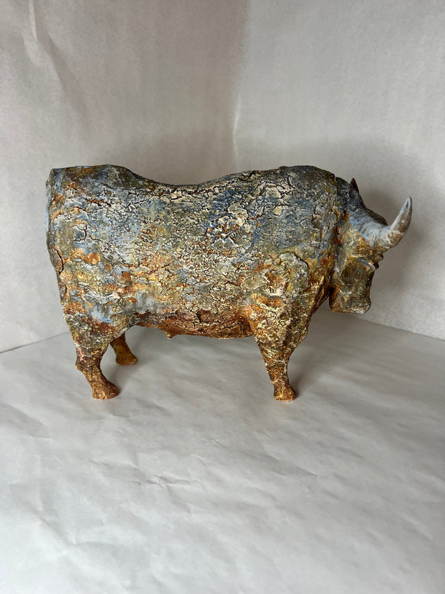 Keramikskulptur af bison i profil med ru lagdelt overflade i blågrå og gyldne toner