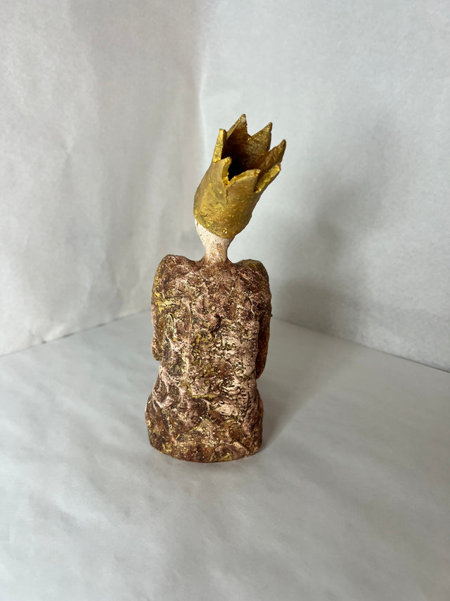 Keramikskulptur med gylden krone set bagfra, ru brun og rødlig overflade