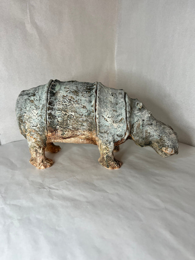 Keramikskulptur af flodhest set fra siden, viser den cylindriske krop og de korte ben