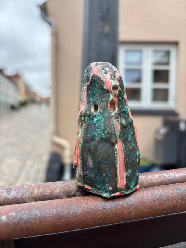 Booh 07 set forfra med to ovalformede ojenhuller i dramatisk patina mod Ebeltoft bymidte