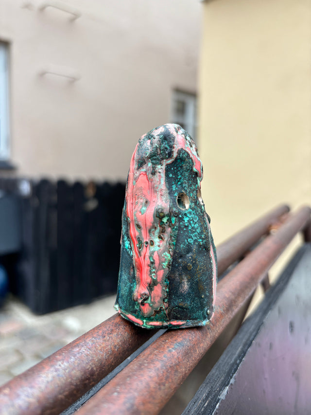 Booh 07 set fra siden med levende koralroede striber i mork bronzeoverflade