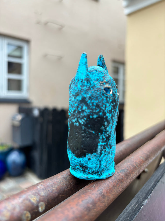 Booh 04 set fra siden paa raekvaerk med det elektriske turkisblaa moenster i bronzeoverfladen