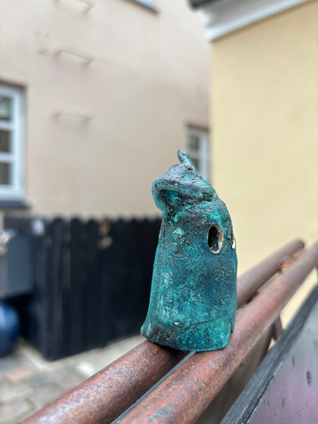 Booh 06 set fra siden med karakteristisk oorform og ru turkisgroen bronzeoverflade