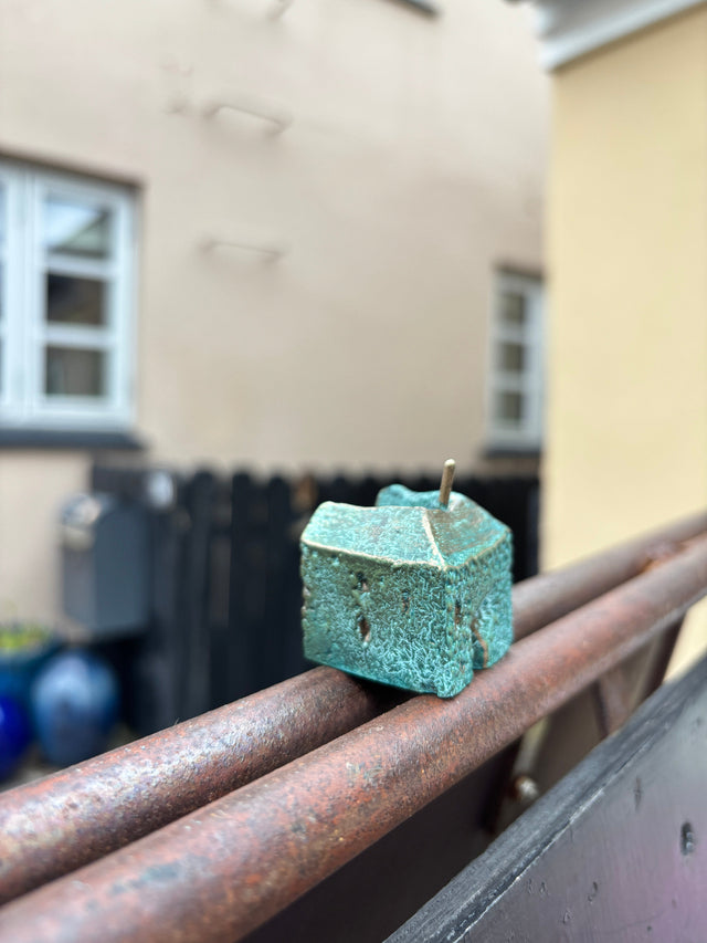 Hus #14 fra Harritsø på en rusten gelænder - kompakt blågrøn bronze skulptur