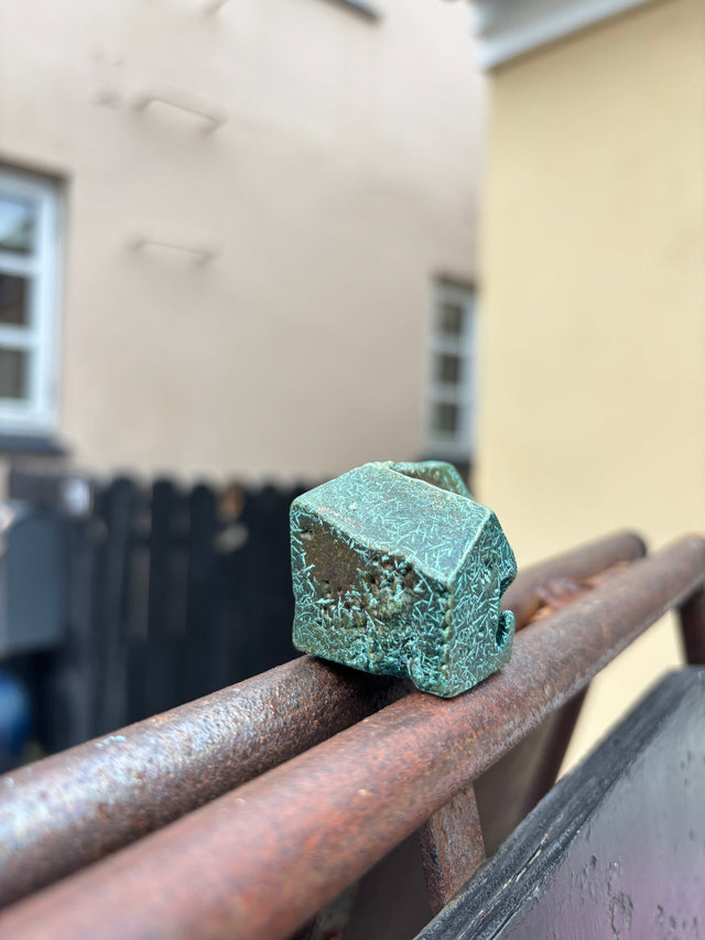 Hus #15 fra Harritsø på en rusten gelænder - blågrøn bronze skulptur med krystallinsk overflade