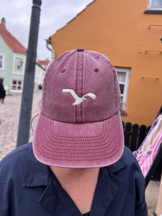 Kasket med broderet flyvende svane i bordeaux rød fra Rustfelt, fotograferet i Ebeltoft
