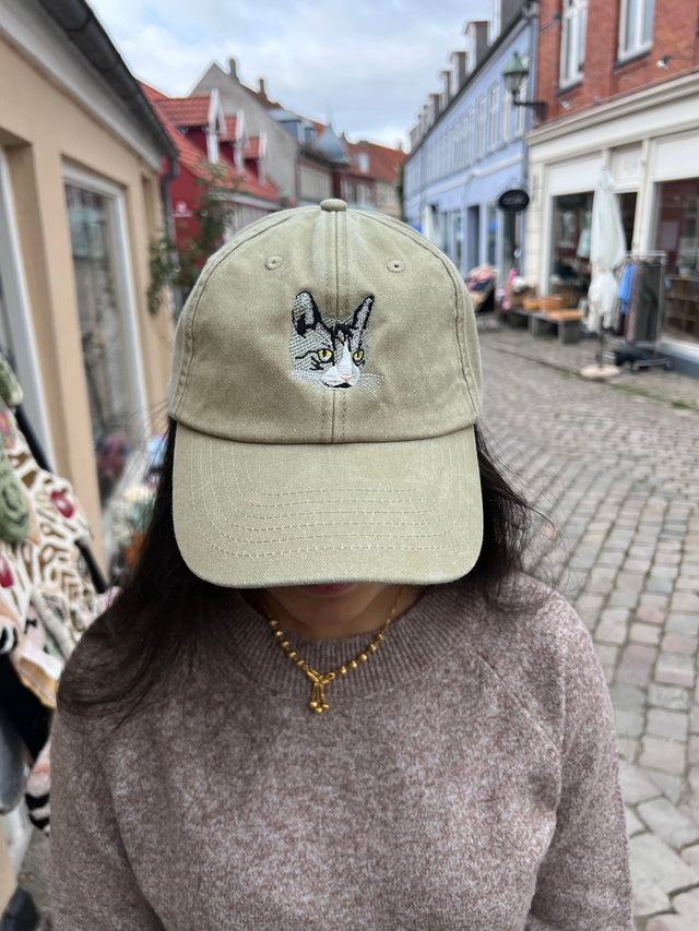 Kasket med broderet grå kat i sand fra Rustfelt, fotograferet i Ebeltofts gågade