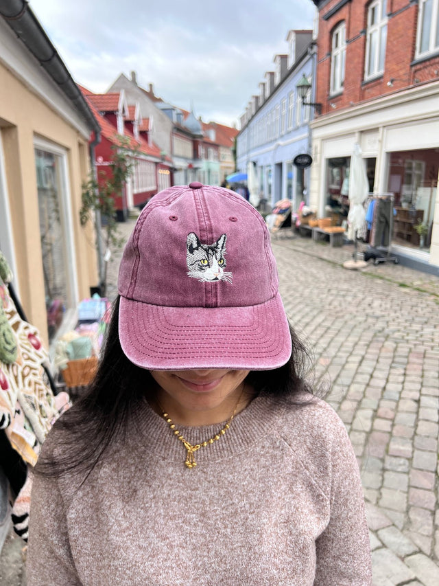 Kasket med broderet grå kat i bordeaux rød fra Rustfelt, fotograferet i Ebeltofts gågade