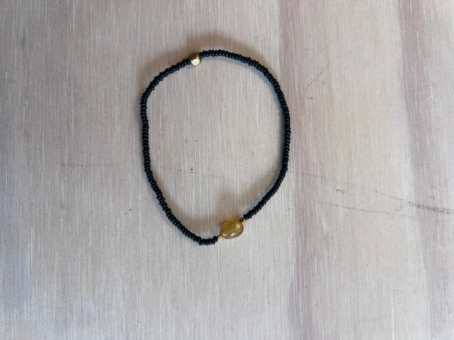 Armbånd Nuri i sort fra Annavii - sorte glasperler med stor gul honningsten og guld