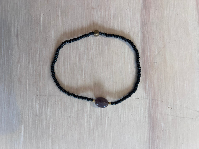 Armbånd Nuri i sort fra Annavii - sorte glasperler med rund lilla sten og guld kugle