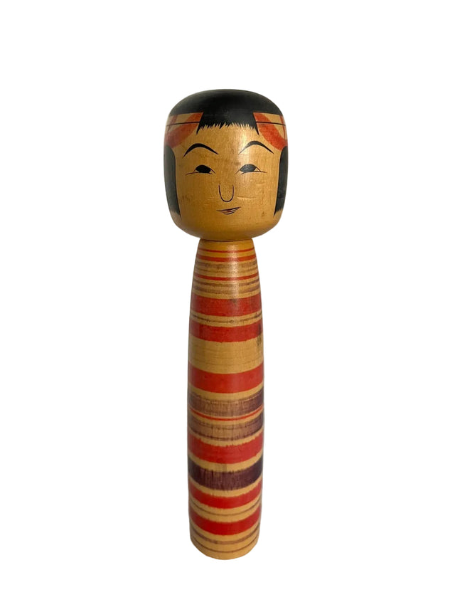 Vintage kokeshi dukke med røde og brune striber i varierende bredder med lilla bånd. 26 cm