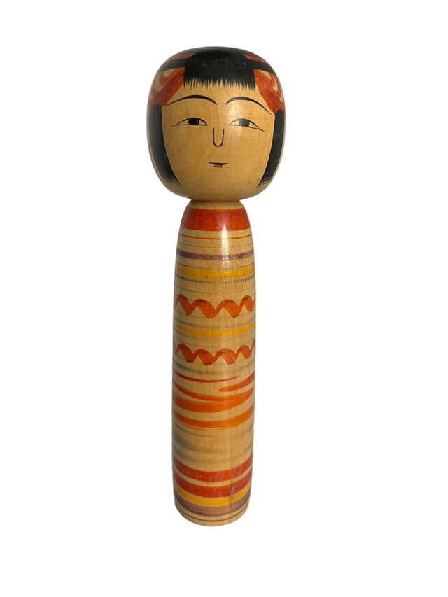 Vintage kokeshi dukke med orange, gule og lilla striber og bølgemønster på lyst træ. 25 cm