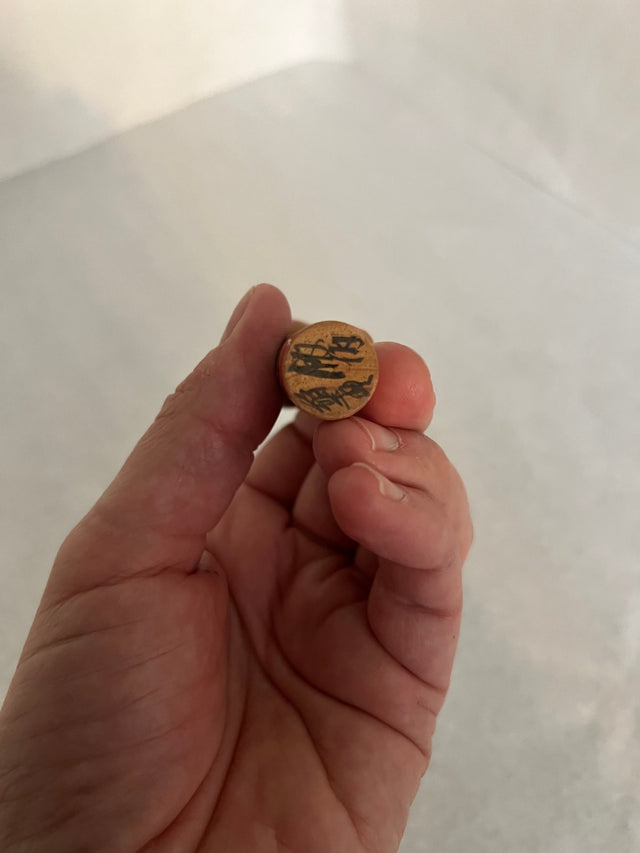 Nærbillede af håndmalet ansigt på vintage kokeshi #29. Rød hat. 10 cm