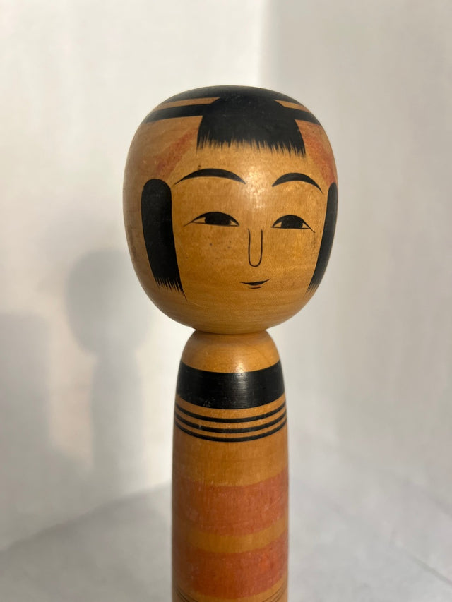 Nærbillede af håndmalet ansigt på vintage kokeshi #17. Venligt smilende ansigt. 25 cm