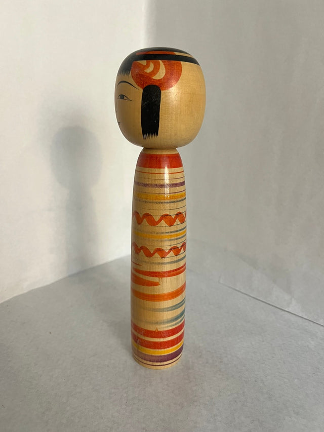 Vintage kokeshi #13 set fra siden. Multifarvet stribemønster. 25 cm