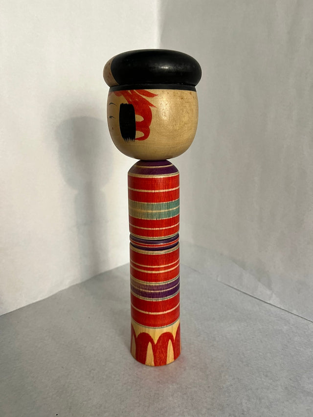 Vintage kokeshi #11 set fra siden. Røde og lilla striber med sort hat. 31 cm