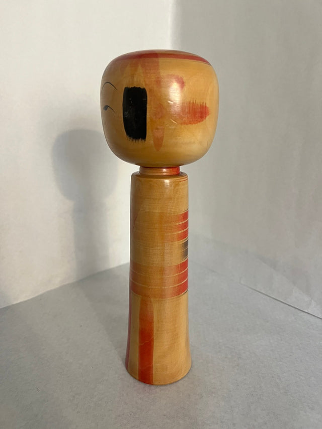 Vintage kokeshi #19 set fra bagsiden. Amber træ med røde geometriske figurer. 25 cm