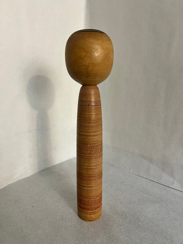 Vintage kokeshi #15 set fra bagsiden. Gyldent træ med svage striber. 25 cm