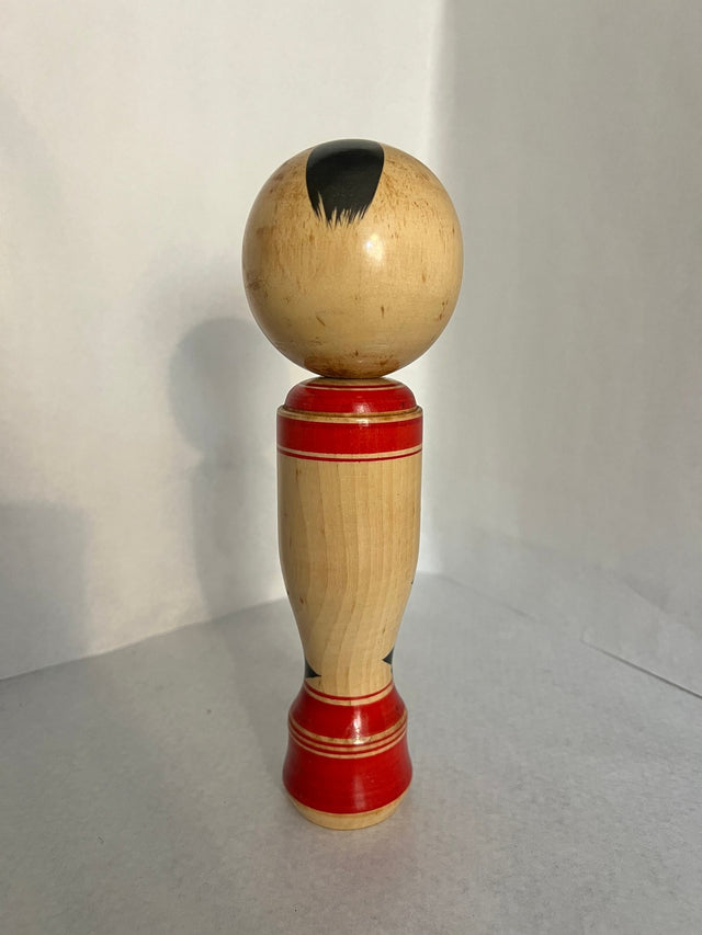 Vintage kokeshi #16 set fra bagsiden. Rød krop med sort blomstermønster. 24 cm