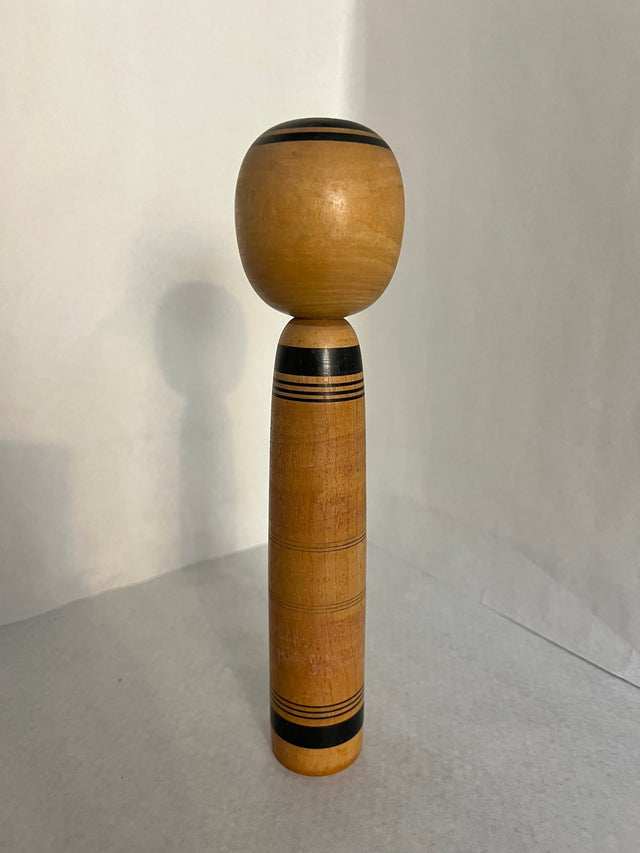 Vintage kokeshi #17 set fra bagsiden. Gyldent træ med orange striber. 25 cm