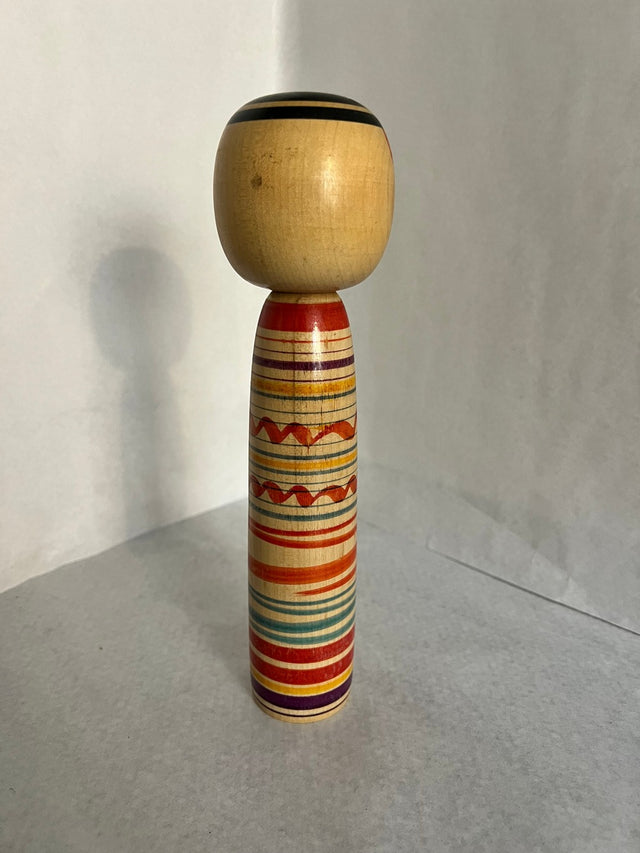 Vintage kokeshi #13 set fra bagsiden. Orange, gule og lilla striber. 25 cm