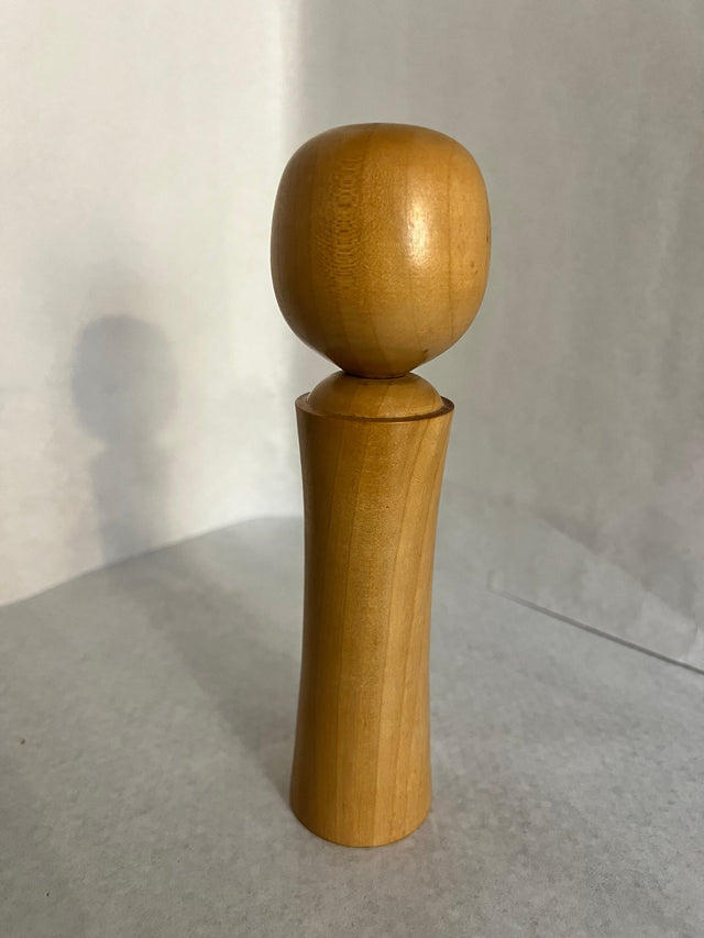 Vintage kokeshi #21 set fra bagsiden. Konisk form med røde motiver. 19 cm