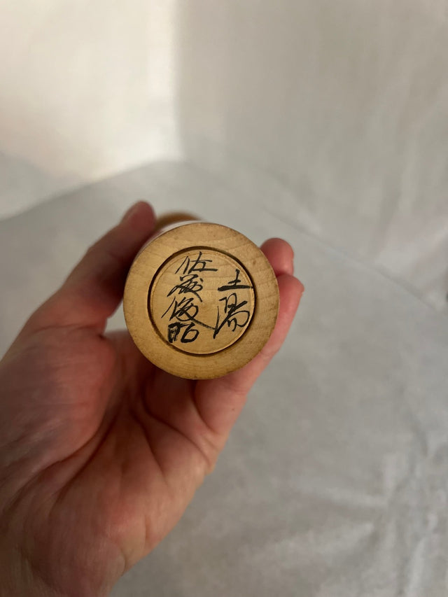 Vintage kokeshi #14 i skrå vinkel. Detalje af røde og brune striber. 26 cm