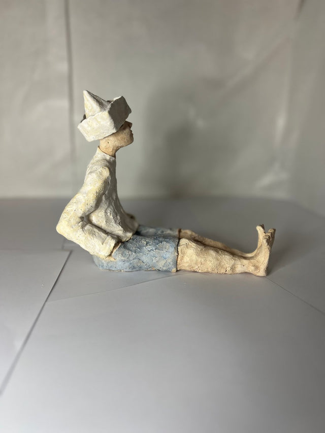 Mand med avishat 02, siddende figur i keramik med blå bukser - Ponyklubben